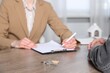 © New Africa - Real estate agent working with client at wooden table indoors, closeup