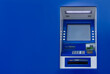 © vadish - A blue ATM machine is mounted on a matching blue wall. Financial services and technology.