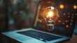 © Pixelzone - Floating light bulb on laptop showing technology innovation and startup concept. Business idea and innovation concept.