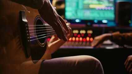 Leinwandbilder - Skilled composer producing and recording new track on guitar, creating a live performance in control room. Songwriter artist composing music for his new album. Close up. Camera B.