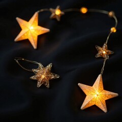 twinkling christmas star garlands on black fabric, black background, holiday gift wrap, decorative s