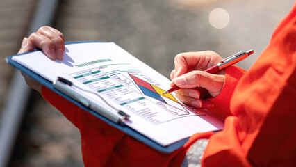 Wall Mural - close-up at safety supervisor's hand during writing on chemical safety checklist to verify the hazar