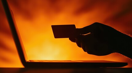 Poster - Hand holding credit card by laptop in warm ambient light