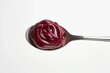 © Amal - A spoonful of rich, dark red berry preserves or jam, glistening and thick.