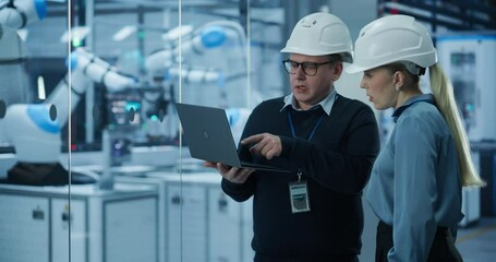 Fototapete - Electronics Factory: Female Project Manager and Engineer in Hard Hats, Talking, Using Laptop. Monitoring Advanced Equipment Production. Robotic Arms Assembly Line Manufacturing Circuit Boards