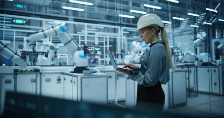 Leinwandbilder - Portrait of a Female Engineer in a Hard Hat Working in an Industrial Facility. Industrial Manager Using Laptop Computer to Monitor Robotic Arms in a Futuristic Electronics Factory
