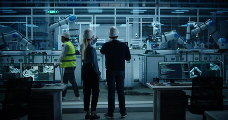Leinwandbilder - Manufacturing Robot Administrators Coming In to Program Production Systems at an Electronics Factory. Back View Footage of a Male and Female Supervising Assembly with a Laptop Computer