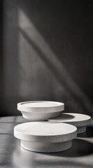 Poster - Elegant minimalist backdrop featuring three round stone platforms under a soft natural light beam for product display