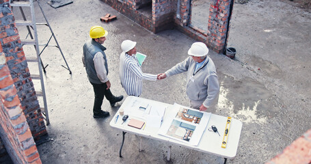 Aufkleber - Team, handshake and people on construction site for plan, inspection or collaboration at table. Contractor, welcome and woman with tablet for blueprint, brainstorming or architect design from above