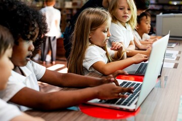 Poster - Diverse students, girls and boys, learn on laptops in classroom. Diverse students focused on their laptops, learning together. Diverse student learning through laptop. Boys and girls learning, laptop