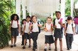 © Rawpixel.com - Group of diverse young children in school uniforms walking together. Diverse elementary students with backpacks enjoying school. Happy diverse elementary students wearing school uniforms.