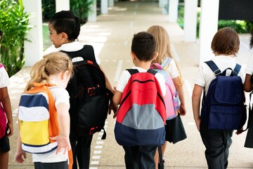 Poster - Children with backpacks walking together. Kids with backpacks heading to school. Group of children, diverse, with colorful backpacks. School day for kids. Diverse small school kids with backpacks.