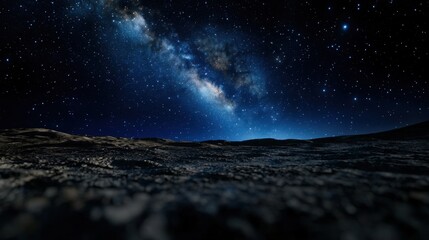 Wall Mural - Stars fill the sky in a breathtaking display, with the Milky Way brightly shining above a rugged terrain. This nighttime scene captures the beauty of the universe