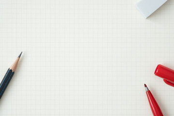 Wall Mural - top view, close-up of red felt-tip pen, pencil and eraser on graph paper background, copy space for 