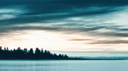 Wall Mural - serene sunset over a tranquil lake with silhouetted trees and soft clouds in the background