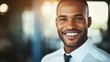 © Dylan - Young man smiling confidently in professional attire, conveying success and self-assurance in a modern workplace.