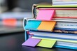 © Iftikhar alam - A close-up of a stack of colorful textbooks with bright bookmarks sticking out, A stack of textbooks with colorful bookmarks sticking out