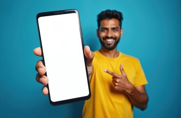 happy indian man points finger at smartphone. mobile app advertisement, modern tech. smiling guy sho