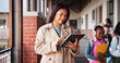 © Einero/peopleimages.com - Education, woman and teacher with tablet, school and lesson planning on website, browsing and smile. Happy, educator and person with tech for curriculum, scroll and knowledge for children or hallway