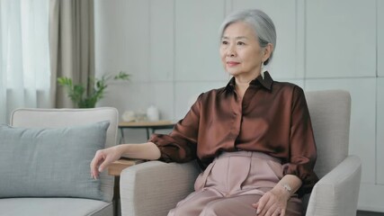 Aufkleber - A woman sitting in a comfortable-looking chair in a cozy living room.