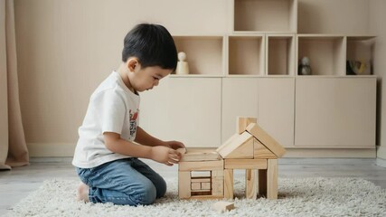 Poster - A young boy playing with wooden blocks on the floor, perfect for illustrations of childhood innocence and creativity.