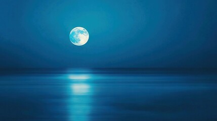 Wall Mural - a bright full moon glows in the blue sky, casting light on a tranquil body of water below