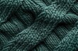 © Anjali - Close-up of dark teal knitted fabric showing intricate texture and weave.