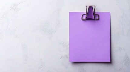 Poster - A Close-Up View of a Purple Blank Paper Sheet Secured with a Clip on a Light Background, Ideal for Creative Presentations and Note Taking