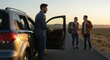 © Vyatcheslav - Friends chatting by a car at sunset on a rural road