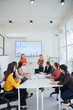 © aekachai - Group of Asian female business people discussing presentations at the office.