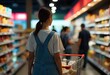 © Halim - Woman pushes shopping cart in supermarket aisle for groceries
