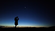 © astrosystem - Amateur astronomer looking at the evening skies, observing planets, stars, Moon and other celestial objects with binoculars.