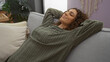 © Krakenimages.com - Woman relaxing on couch in cozy living room with stylish decor, showing peaceful and content expression indoors at home.
