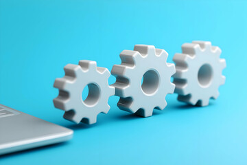 Aufkleber - A close-up of three white gears on a blue background next to a laptop, symbolizing technology, engineering, and mechanical processes.