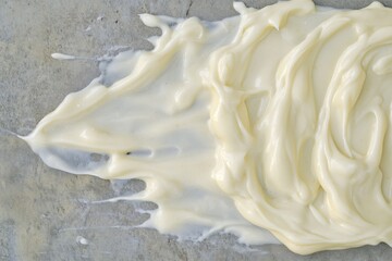 Poster - Creamy White Texture: A smooth and thick spread of a creamy white substance creates an abstract pattern with a textured surface.