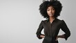 © Johannes - Portrait of young african american woman standing with hands on waist and looking at camera. Confident stylish black girl standing against grey background. Happy afro girl smiling with copy space.