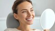 © NovaVision - A beautiful woman checks her perfect, white teeth in a mirror, radiant with a happy smile.