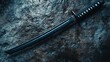 © jago - Polished katana blade rests on a textured stone surface.