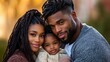 © Enrique - A family of three shares a joyful moment outdoors on a sunny afternoon. The parents embrace their young child, all smiling warmly while surrounded by nature's beauty
