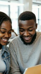 Poster - A young man , woman are working closely together on digital tablet, both smiling , looking down at screen. The warm light of screen illuminates their faces, suggesting collaboration , shared success.