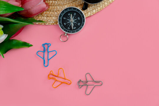 Paper clips in the form of airplanes on a pink background, the concept of travel, the place of the text