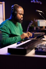 Aufkleber - Music technician with headset mixing and mastering his audio recordings, operating on a console in home studio. Musician producer creating new tunes with sound effects in post production.