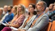© MST - A diverse group of individuals is seated in an auditorium, attentively listening to a presentation