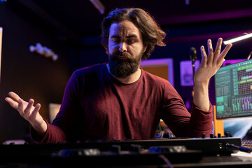 Leinwandbilder - Musician feeling clueless and uncertain while he plays piano notes, trying new midi controller combinations to compose a song. Artist shrugging and being unsure about his song verses.