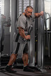 © Vitalii But - professional bodybuilder executes a cable exercise in a well equipped gym focusing on improving muscle tone and overall strength during an intensive training session.