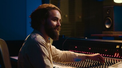 Leinwandbilder - Music engineer working in professional studio control room to do mix and master on audio recordings, editing tunes. Sound technician using sliders and faders on board, stereo equipment. Camera A.