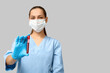 © Pixel-Shot - Portrait of female doctor in mask holding test tube with blood sample on grey background