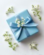 © Nunthaphuk - A beautifully wrapped blue gift adorned with delicate flowers, perfect for celebrations or special occasions.
