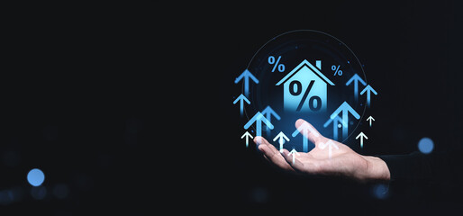 Poster - Conceptual image of rising home interest rates with upward arrows and house icon in a hand on a creative background.