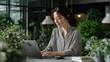 © AnCreaSpace - Focused Woman Working on Laptop in Lush Office